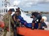 The body of a drowned migrant is being unloaded from a Coast Guard boat in the port of Lampedusa Sicily Thursday Oct 3 2013